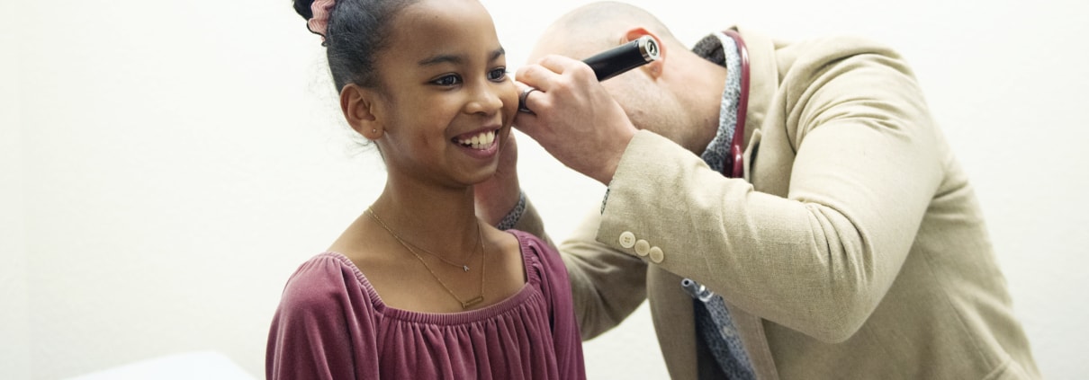 Dr. Garofalo inspects the ear of a smiling child